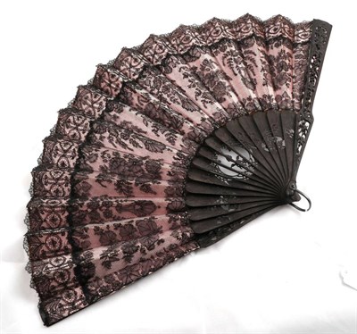 Lot 2101 - Circa 1880-1900 Black Chantilly Lace Fan, backed with pale pink silk, mounted on carved black...