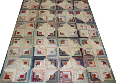Lot 2045 - A Victorian Log Cabin Patchwork Quilt, using printed cottons in blues, purples, reds, pinks and...