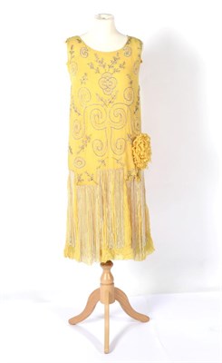 Lot 2127 - A Circa 1920s Yellow Chiffon Sleeveless Shift Dress, with multi pleated skirt hung with strings...