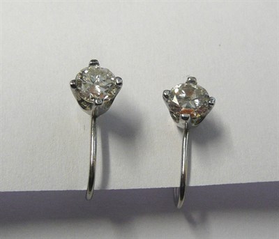 Lot 10 - A Pair of Diamond Solitaire Earrings, the round brilliant cut diamonds held in white four claw...