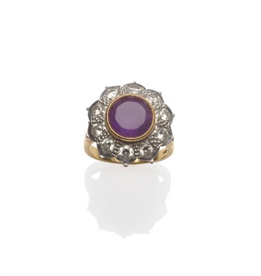 Lot 42 - An 18 Carat Gold Amethyst and Diamond Cluster Ring, a round brilliant cut amethyst in a yellow...