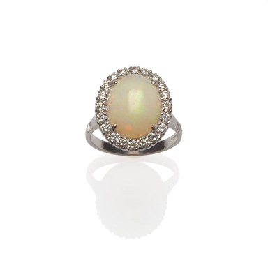 Lot 61 - An 18 Carat White Gold Opal and Diamond Cluster Ring, a cabochon opal within a diamond border,...