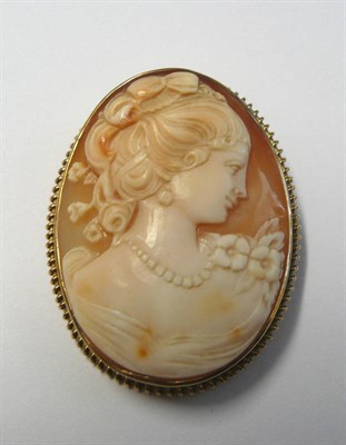 Lot 82 - A 9 Carat Gold Cameo Brooch, the oval shell cameo depicting a pretty young girl, wearing a corsage