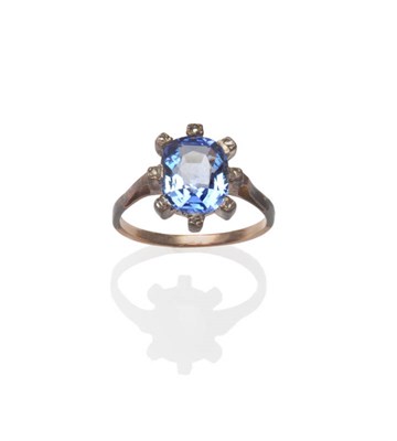 Lot 103 - A Late Victorian Sapphire and Diamond Ring, the cushion cut sapphire within a border of rose...