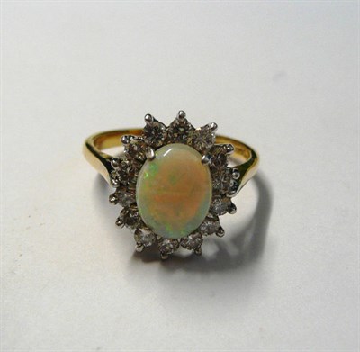 Lot 119 - An 18 Carat Gold Opal and Diamond Cluster Ring, an oval cabochon opal within a border of round...