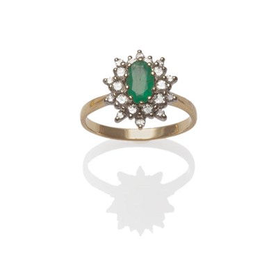 Lot 129 - An Emerald and Diamond Cluster Ring, the oval cut emerald within a border of round brilliant...