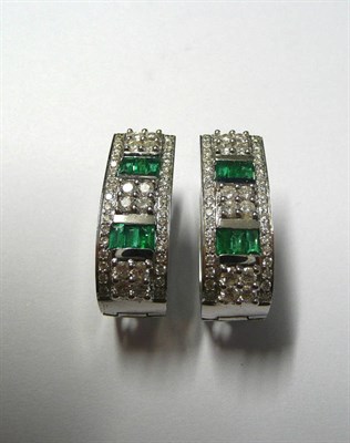 Lot 143 - A Pair of Emerald and Diamond Cuff Earrings, two rows of step cut emeralds spaced by clusters...