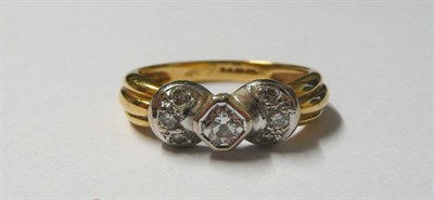 Lot 144 - An 18 Carat Gold Diamond Ring, a mixed cut central diamond flanked by trios of diamonds to each...