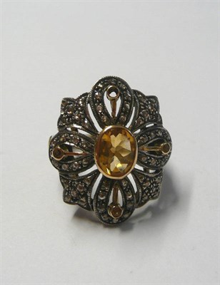 Lot 168 - A Citrine and Diamond Cluster Ring, a central oval cut citrine within an openwork border of...