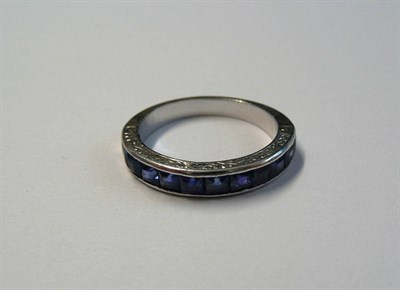 Lot 169 - A Sapphire Half Eternity Ring, the step cut sapphires in a white channel setting with engraved...