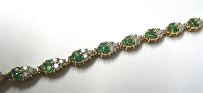 Lot 176 - An Emerald and Diamond Bracelet, comprising lozenge shaped links, each set with a trio of round...