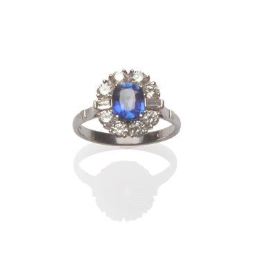 Lot 190 - An 18 Carat White Gold Sapphire and Diamond Cluster Ring, the cushion cut sapphire within a...