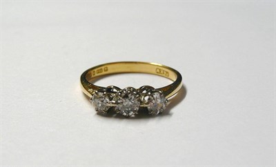 Lot 199 - An 18 Carat Gold Diamond Three Stone Ring, the graduated old cut diamonds in white claw...