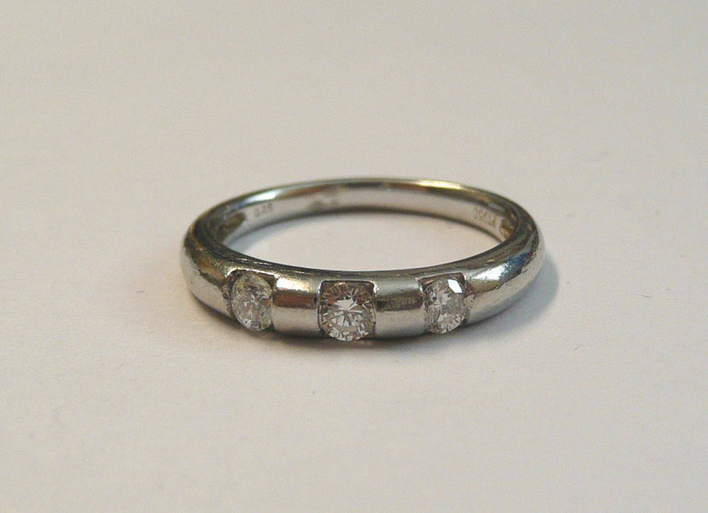 Lot 63 - A Platinum Diamond Set Band Ring, the plain polished band with three round brilliant cut...