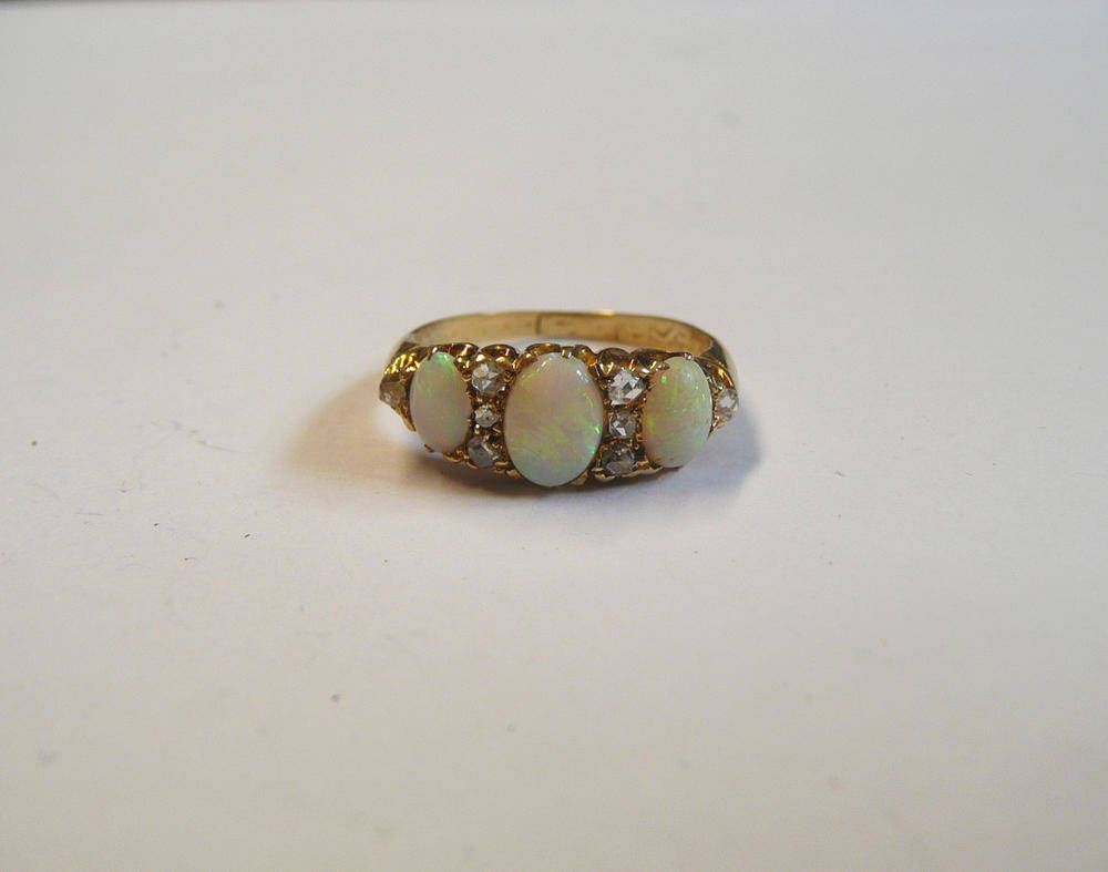 Lot 73 - A Victorian Opal and Diamond Ring, three graduated oval cabochon opals spaced by rose cut diamonds