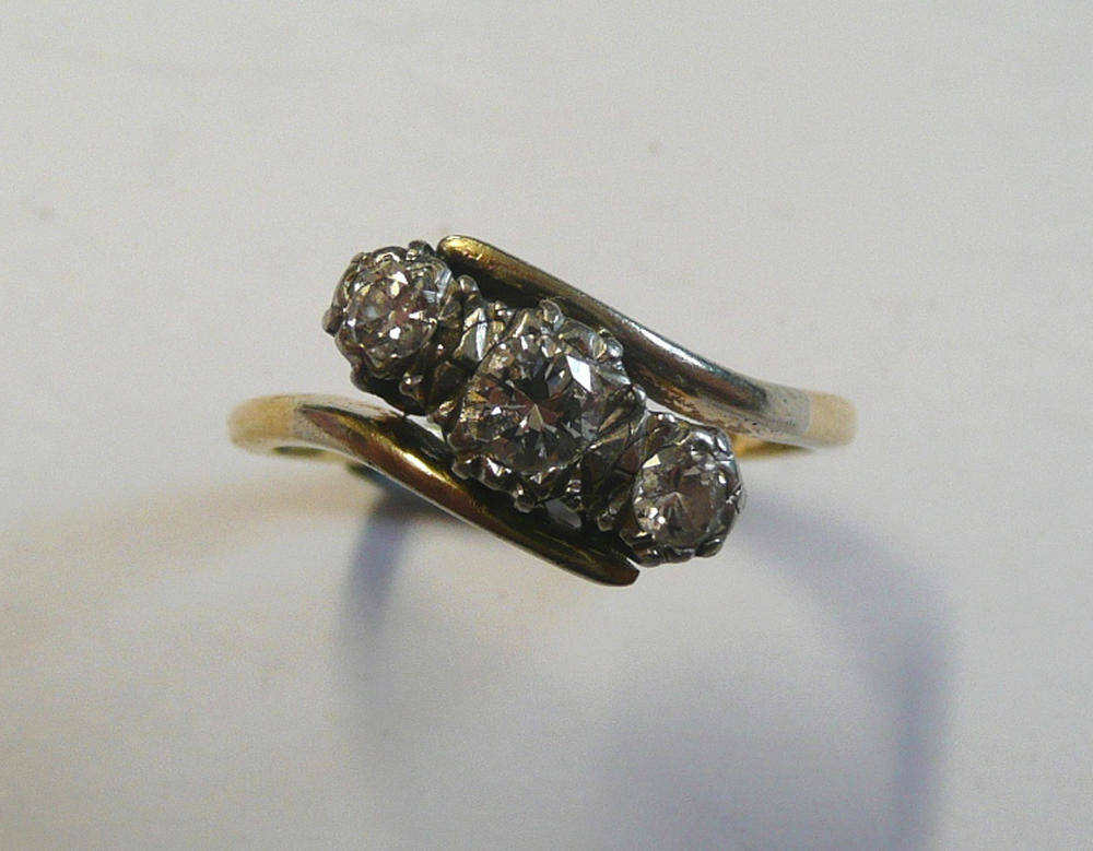 Lot 98 - A Diamond Three Stone Twist Ring, the graduated round brilliant cut diamonds in white settings...