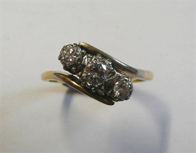 Lot 98 - A Diamond Three Stone Twist Ring, the graduated round brilliant cut diamonds in white settings...