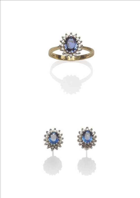 Lot 127 - An 18 Carat Gold Sapphire and Diamond Cluster Ring, the oval mixed cut sapphire within a border...