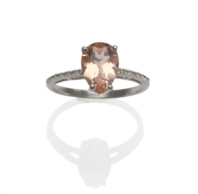 Lot 134 - A 9 Carat White Gold Morganite and Diamond Ring, the pear cut morganite in a four claw setting,...