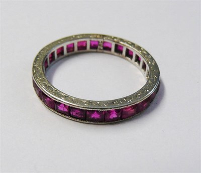 Lot 163 - A Ruby Full Eternity Ring, the square cut rubies channel set within a white engraved sided...