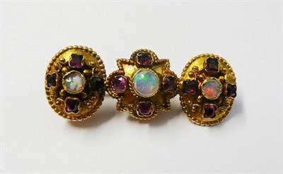 Lot 166 - An Opal and Ruby Bar Brooch, a star shape flanked by two ovals, each set with a cabochon opal...