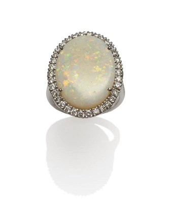 Lot 173 - An 18 Carat White Gold Opal and Diamond Cluster Ring, an oval opal within a border of round...