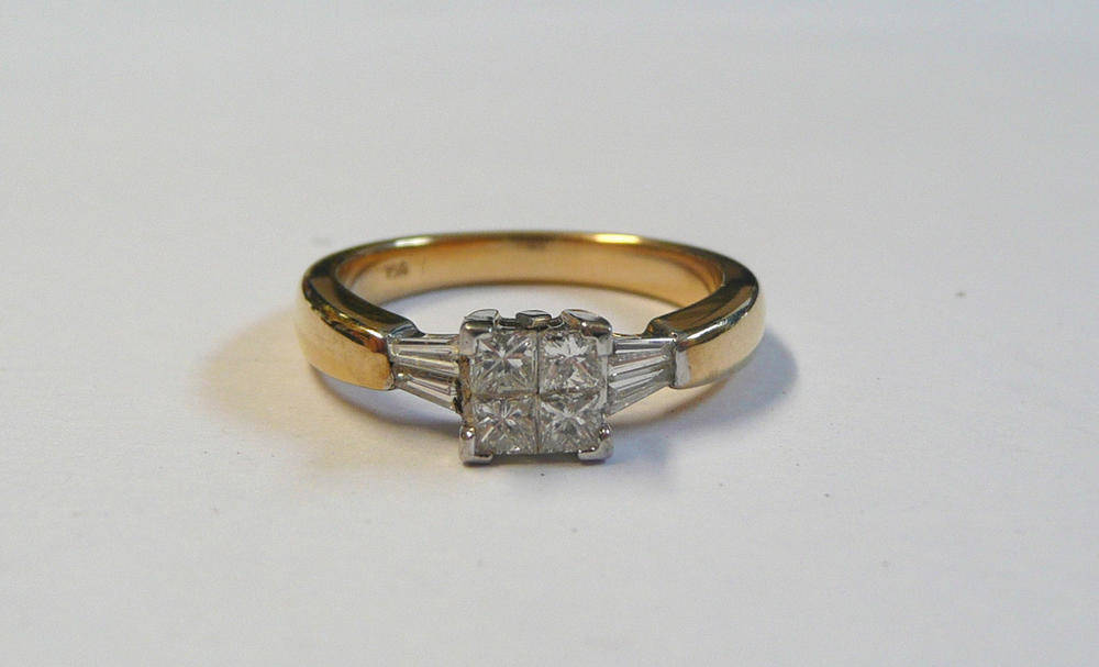 Lot 186 - A Diamond Set Ring, a cluster of four princess cut diamonds tension set between four white claws, a