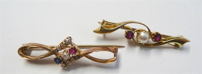 Lot 195 - A Half Pearl and Ruby Three Stone Brooch, the stones in yellow claw settings, to scrolling...