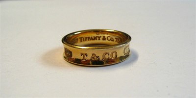 Lot 217 - An 18 Carat Gold Band Ring, by Tiffany, the concave band with an enlarged '750', 'T&CO and...