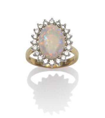 Lot 1021 - An 18 Carat Gold Opal and Diamond Cluster Ring, an oval cabochon opal within a border of round...