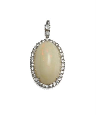 Lot 1062 - An 18 Carat White Gold Opal and Diamond Cluster Pendant, the oval cabochon opal within a border...