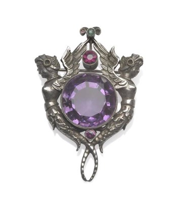 Lot 1077 - An Arts and Crafts Brooch, a large round cut amethyst in a white millegrain setting, within figures