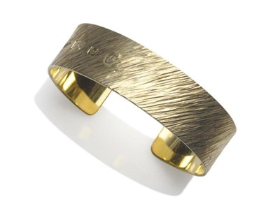 Lot 1078 - A Silver Gilt Bangle, by Gerald Benney, the cuff bangle with textured brushed finish, depth...