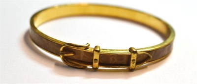 Lot 1084 - A Bangle, by Hermes, the gold plated bangle with buckle detail, and an insert of beige leather, and