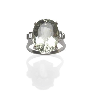 Lot 1095 - A Green Quartz and Diamond Ring, the oval cut pale green stone flanked by two graduated...