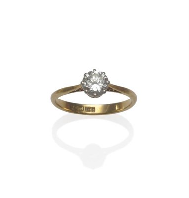 Lot 1115 - A Diamond Solitaire Ring, the round brilliant cut diamond in a white claw setting to a yellow...