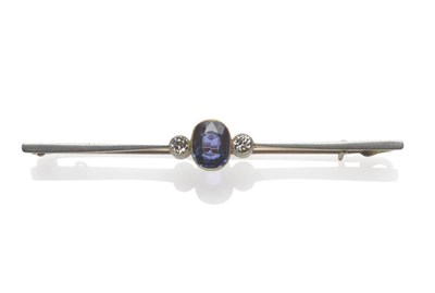 Lot 1126 - A Sapphire and Diamond Bar Brooch, the oval mixed cut sapphire flanked by an old cut diamond to...