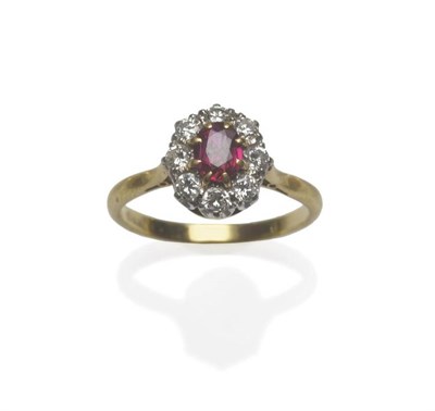 Lot 1155 - A Ruby and Diamond Cluster Ring, the oval mixed cut ruby within a border of round brilliant cut...