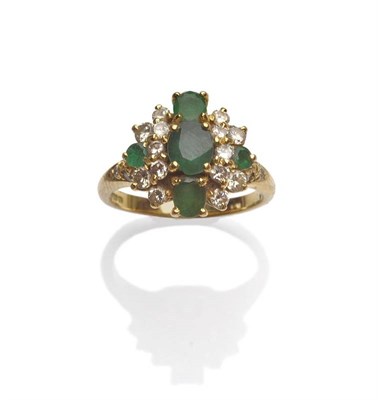 Lot 1168 - An 18 Carat Gold Emerald and Diamond Ring, three oval cut emeralds centrally within a clustered...