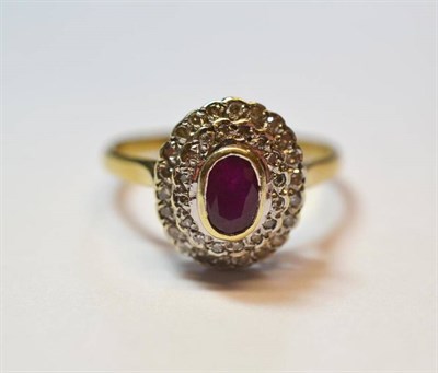 Lot 1195 - A 9 Carat Gold Ruby and Diamond Cluster Ring, an oval cut ruby within a double border of single cut