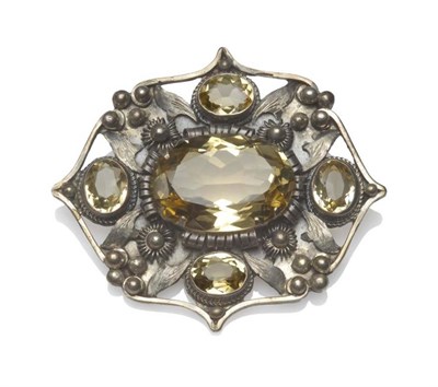 Lot 1215 - An Arts & Crafts Citrine Brooch, a large central oval cut citrine within a pointed frame of...