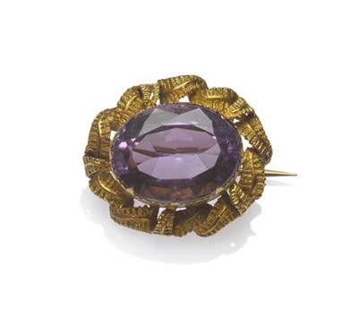 Lot 1003 - An Amethyst Brooch, the oval mixed cut amethyst within a claw tipped bezel setting with...