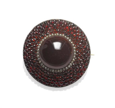 Lot 1010 - A Garnet and Seed Pearl Brooch, circa 1850, the round brooch comprises a central cabochon...