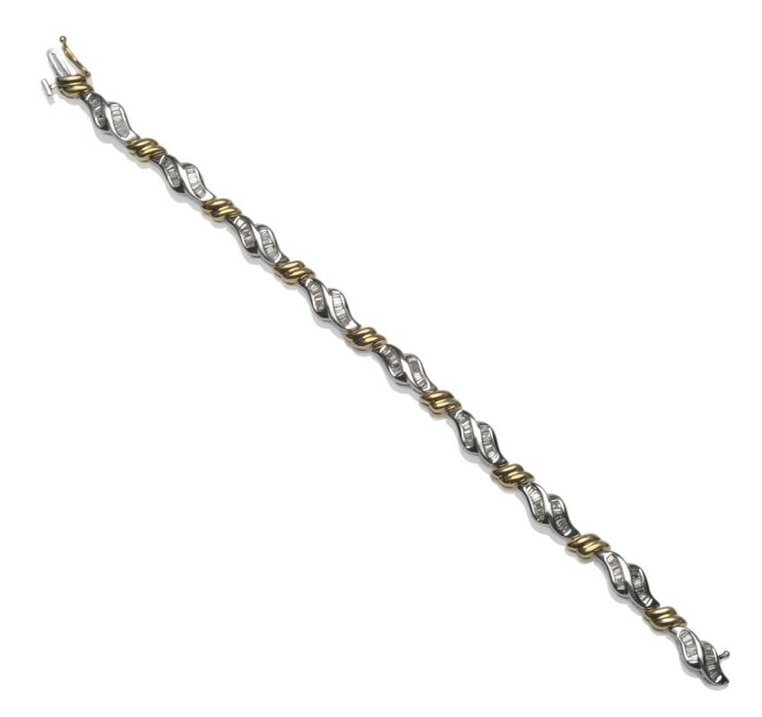 Lot 1028 - A Diamond Set Bracelet, pairs of white scroll forms channel set with baguette cut diamonds...