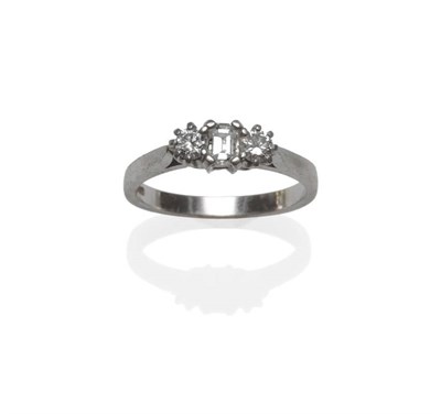 Lot 1030 - A Platinum Diamond Three Stone Ring, an emerald-cut diamond flanked by a round brilliant cut...