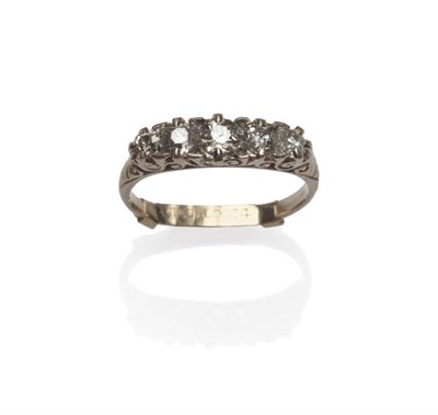 Lot 1040 - A Diamond Five Stone Ring, the graduated old cut diamonds in a yellow claw and carved setting...