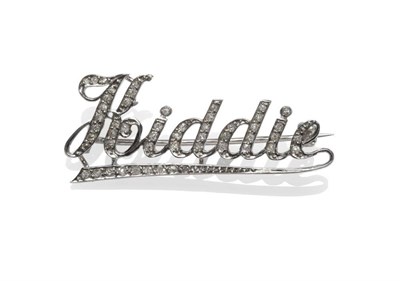 Lot 1046 - A Diamond Brooch, as underlined script spelling 'Kiddie', set with old cut diamonds in white...