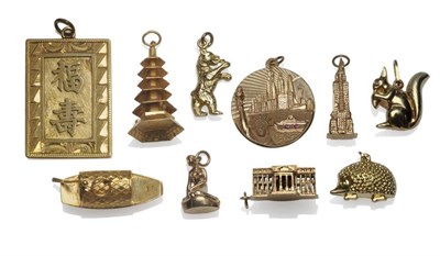 Lot 1063 - Ten Charms, including a squirrel, a hedgehog, a scene of New York, an Eastern panel and a pagoda