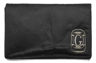 Lot 1072 - A Clutch Bag, with diamond set plaque, of black satin with cream interior, fitted purse,...
