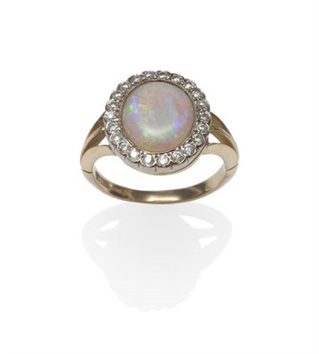 Lot 1086 - An Opal and Diamond Ring, the oval cabochon opal within a border of twenty-two old cut diamonds, in